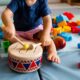 kid playing with toy drums