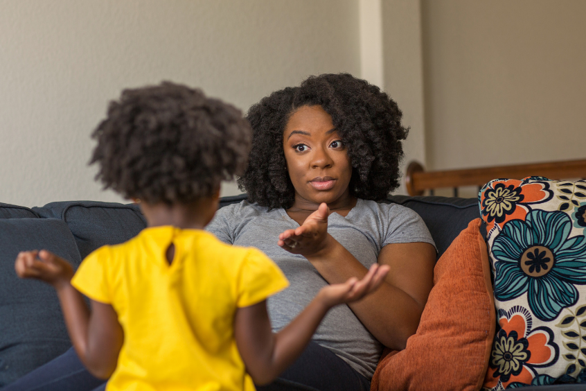 Mother giving instructions to young child at home