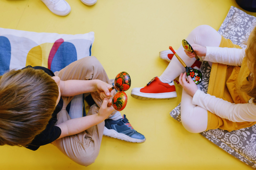Joyful children playing maracas in a colorful preschool setting